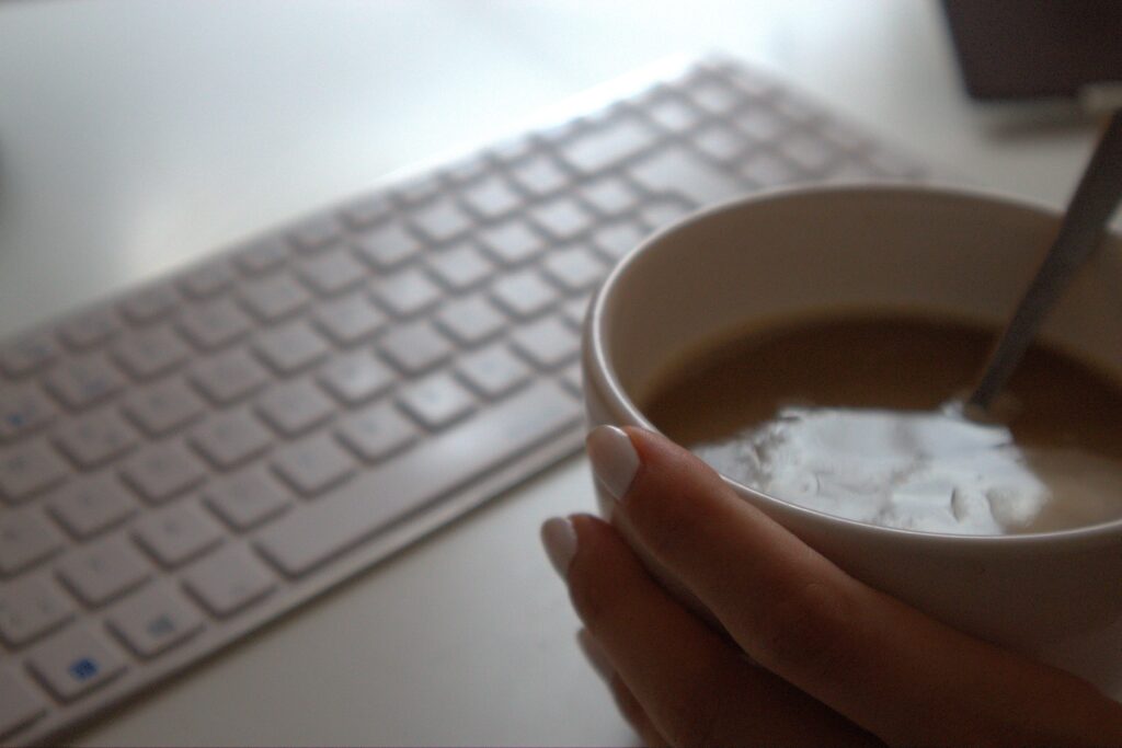 Tasse Kaffee neben einer weißen Tastatur