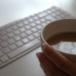 Tasse Kaffee neben einer weißen Tastatur