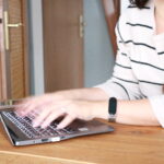 Frau tippt SEO-Texte auf einem Laptop